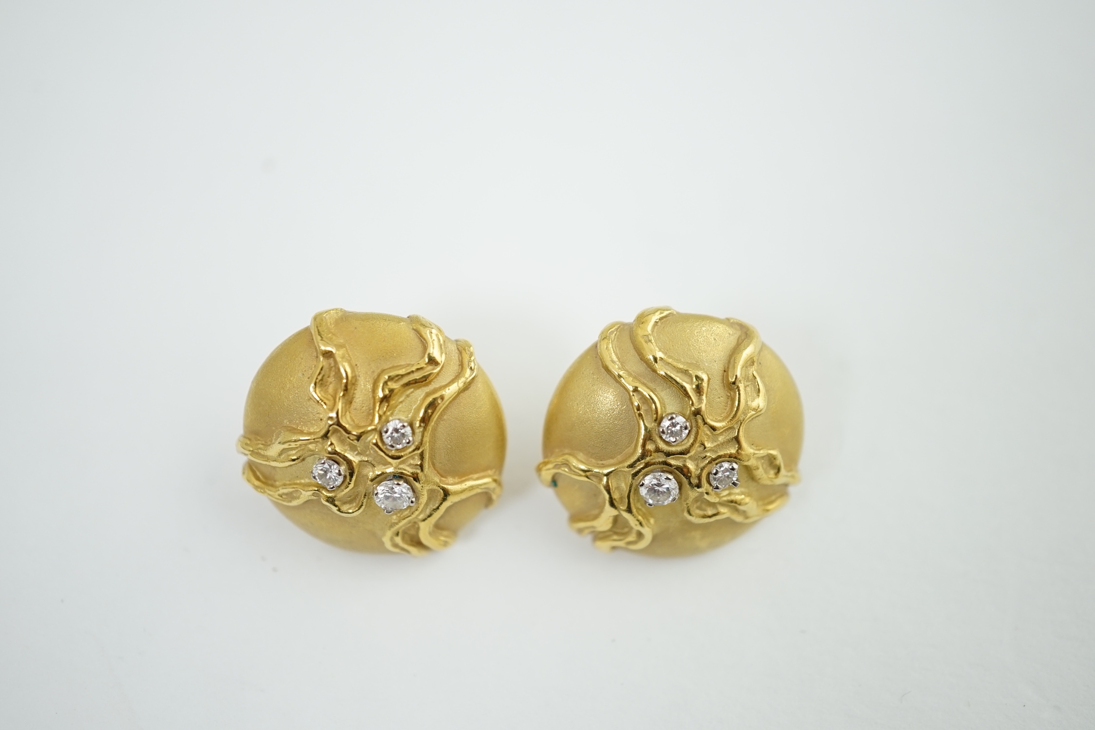 A pair of 18ct yellow gold circular dome stud earrings, each set with three graduated diamonds within a twisted branch design, hallmark London 1974, and matted ground